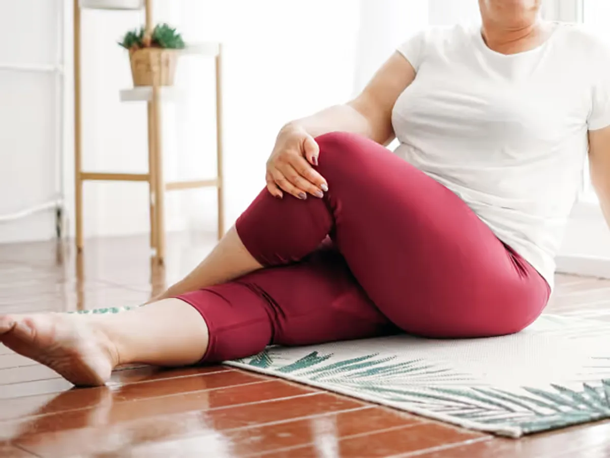 Dame mit Lipödem sitzt auf Yogamatte