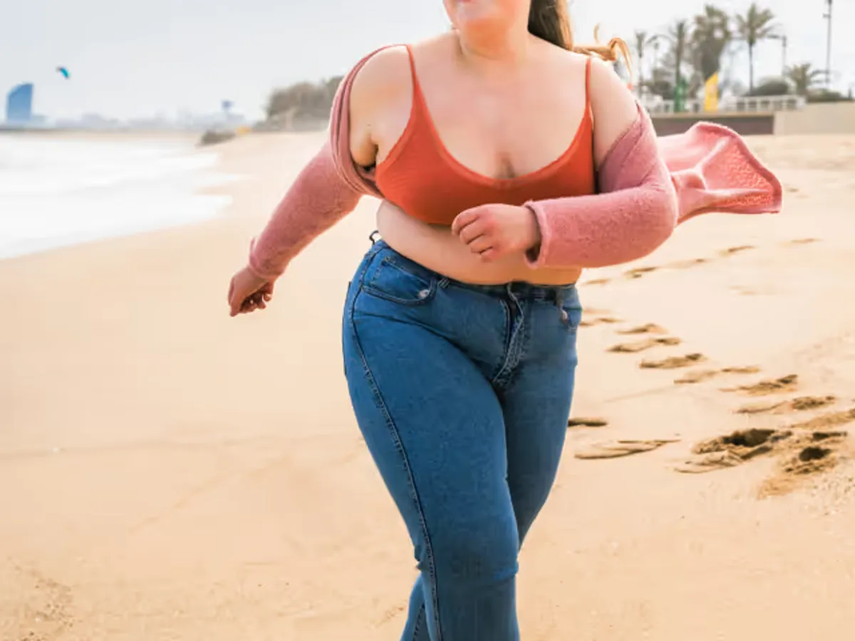 kräftige Frau läuft am Strand - Lipödem oder Übergewicht?